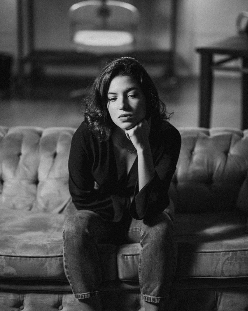 monochrome photography of woman sitting on sofa